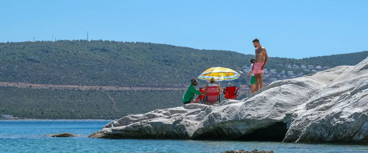 Travelers on a sunny summer beach, a naturist vacation destination